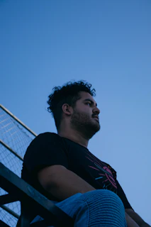 Pinky sitting alone on the bleachers, lost in thought as dusk settles over the track.