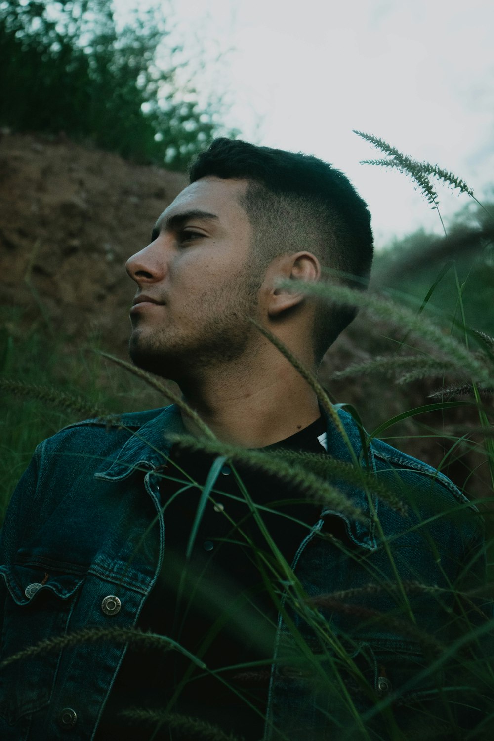 selective focus photography of man behind green plants