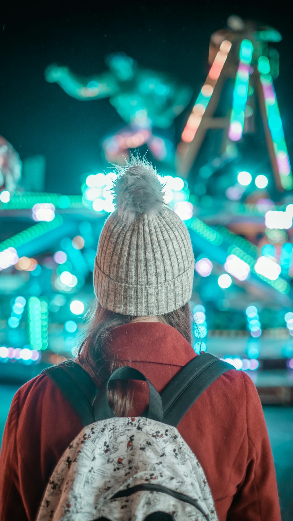 selective focus photography of woman looking at amusement ride at night