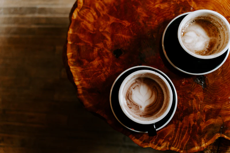 Two coffee cups on a wooden table