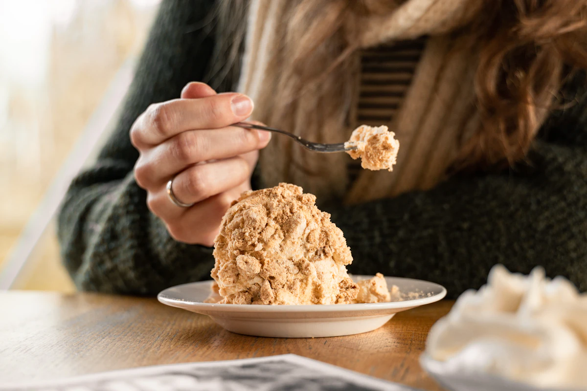 Woman eating a sugary dessert with a spoon