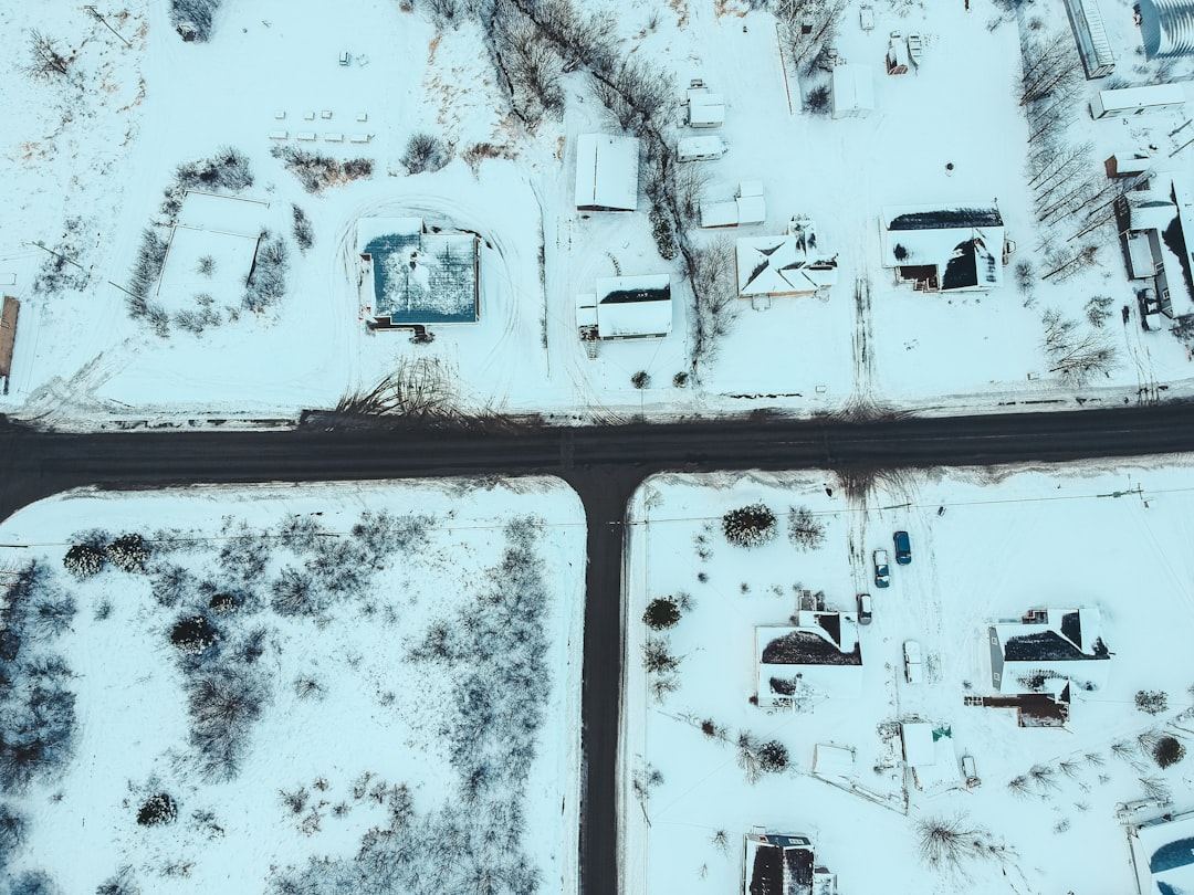 aerial photography of house, field, and trees covered with snow during daytime