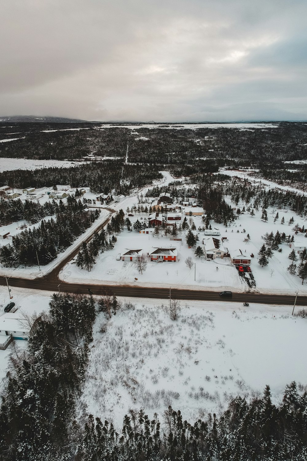 aerial photography of houses and field covered with snow during daytime
