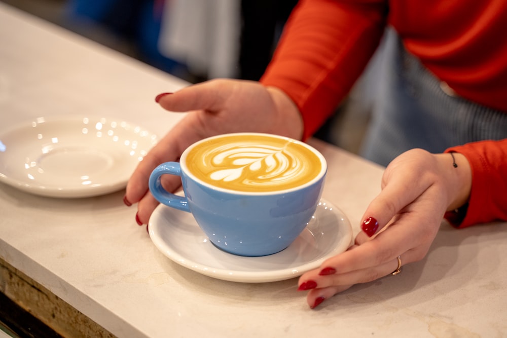 person serving a glass of coffee with latte art