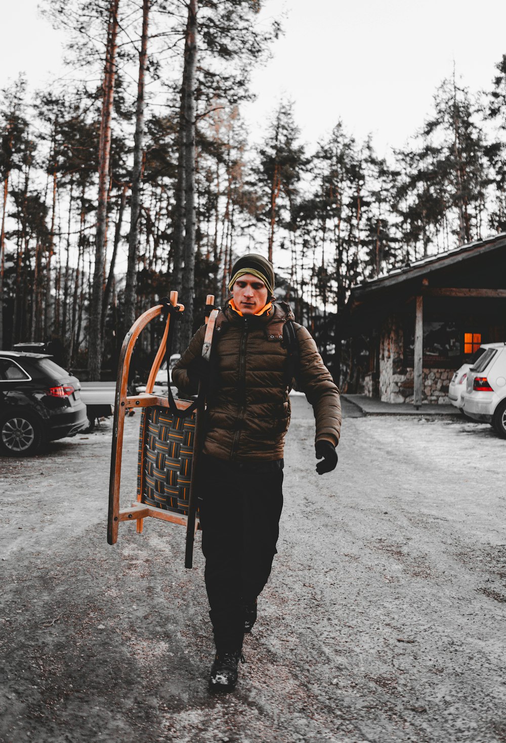 man in gray jacket holding sled