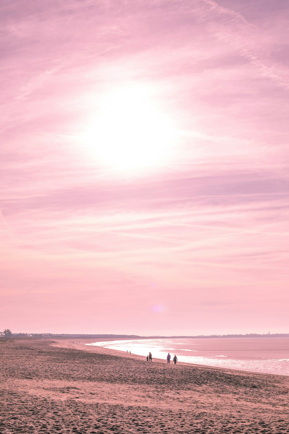 Gente caminando por la orilla del mar durante la hora dorada