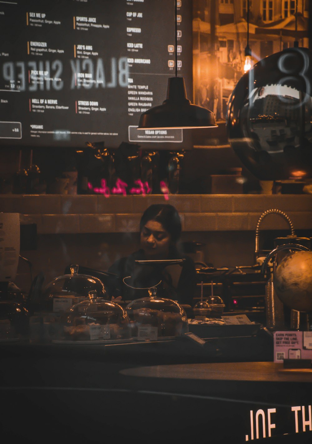 woman standing behind a bar counter in a cafe
