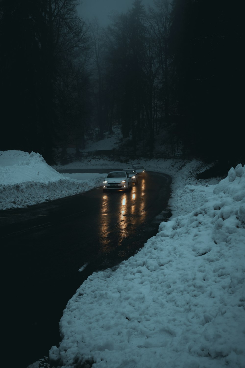 a car driving down a snowy road at night