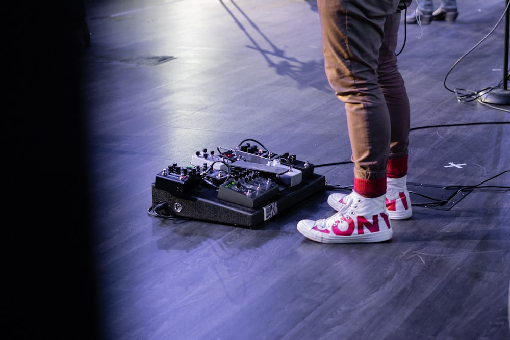 person wearing brown denim jeans standing near audio mixer