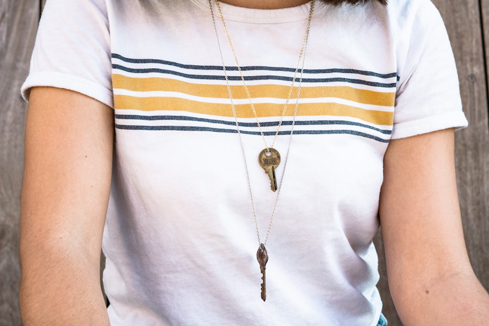 woman wearing silver-colored key pendant necklace