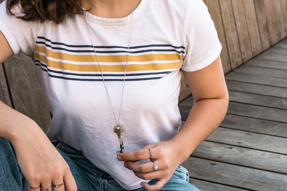 woman holding on to her necklace pendant