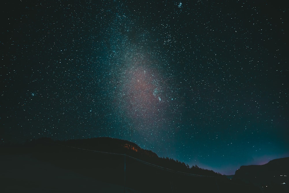 silueta de montañas bajo la noche estrellada