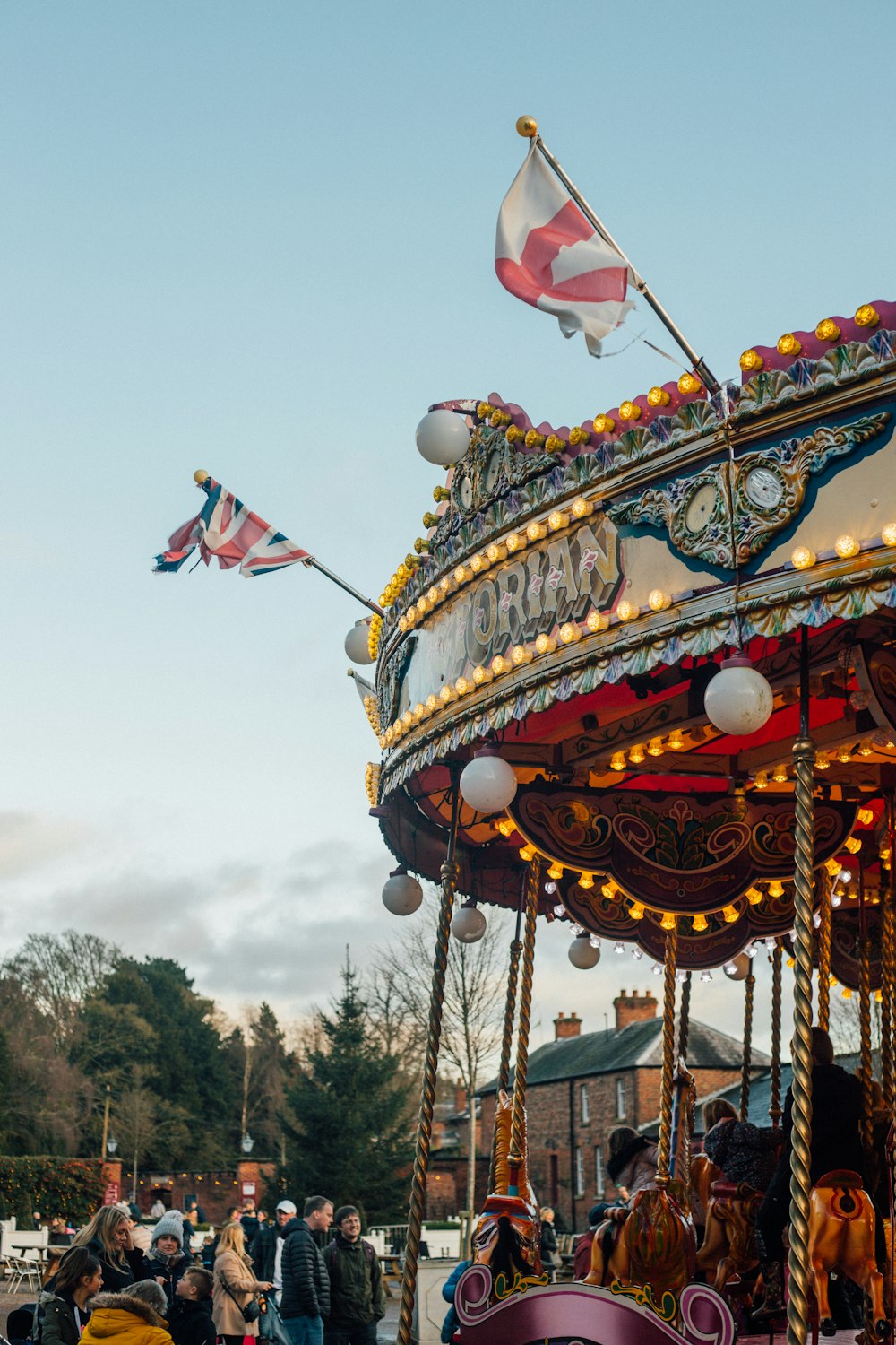 people around a carousel under a calm blue sky during daytime