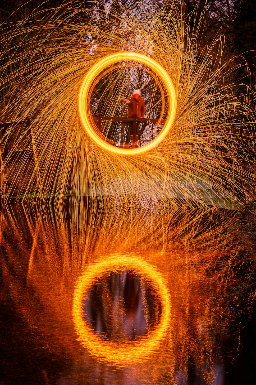 person standing on bridge steel wool photography