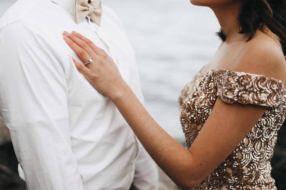 woman in gold off-shoulder dress beside man in white dress shirt