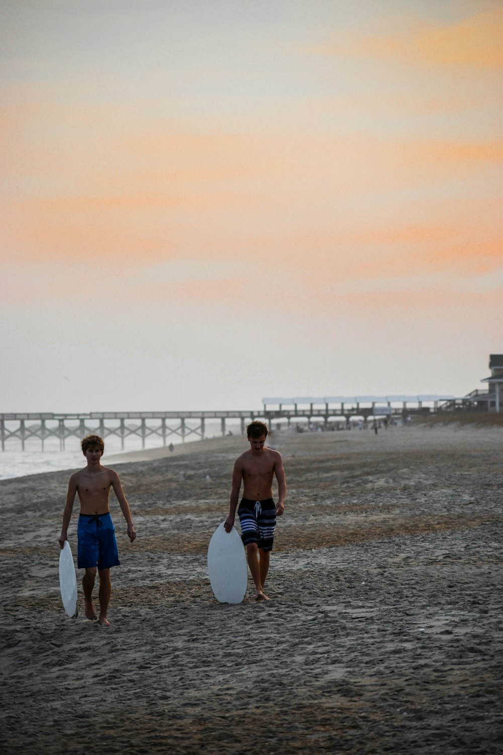 two topless men walking on beach