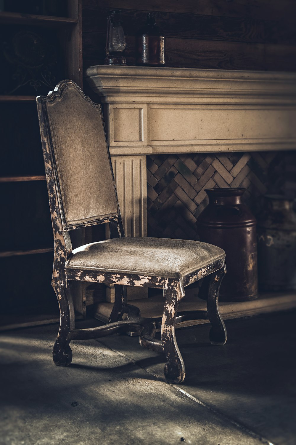uma cadeira velha sentada em frente a uma lareira