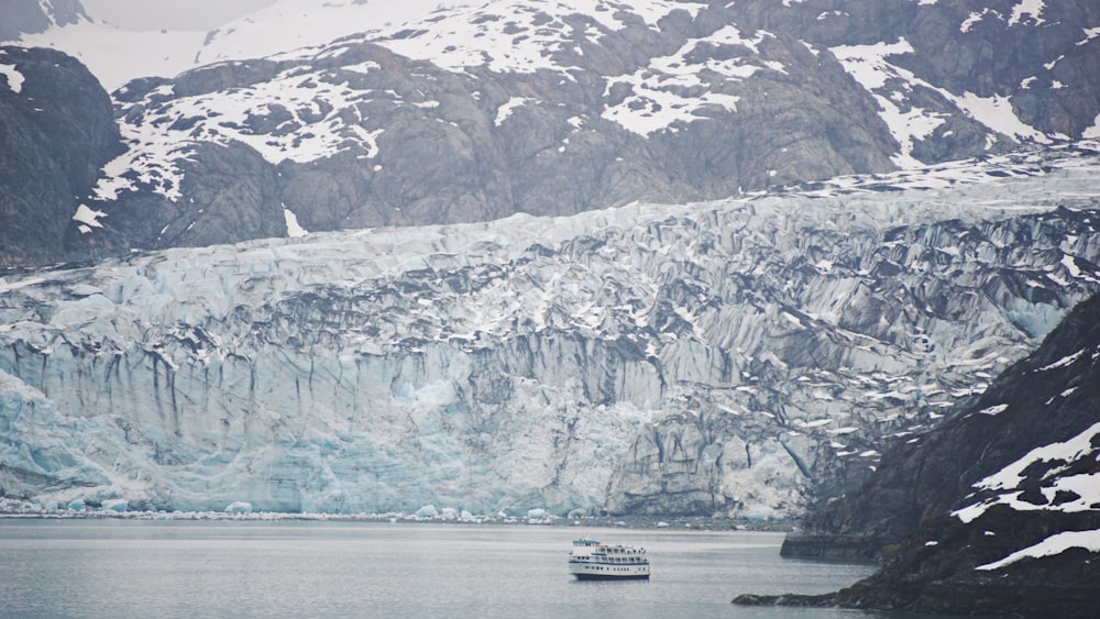 a boat in a large body of water surrounded by mountains