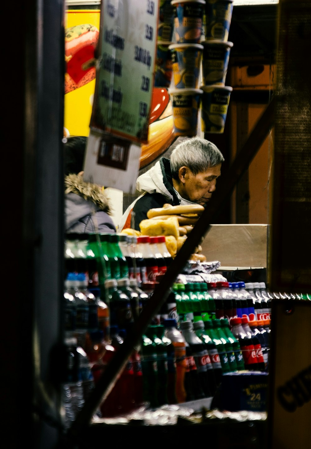 man standing beside soda bottle lot on display