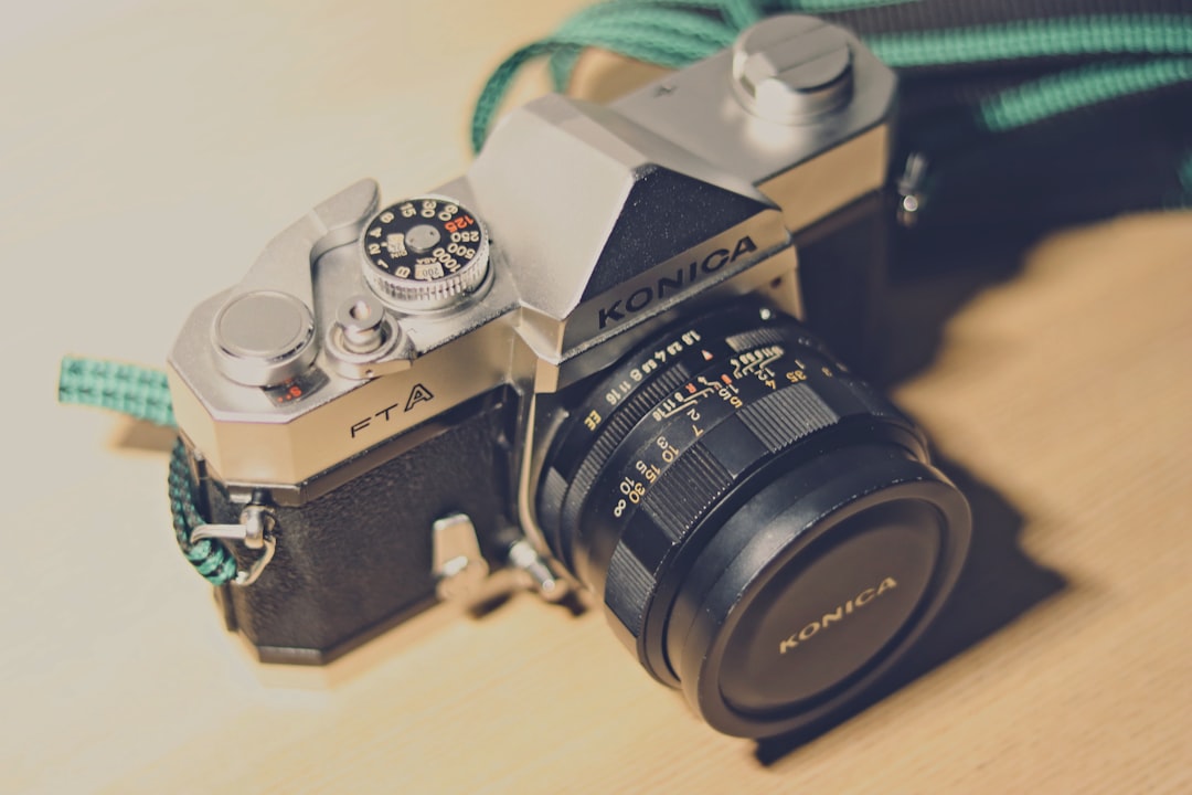 gray and black Konica PT A SLR camera on brown surface