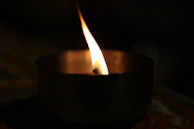 Close-up of a flickering flame in a sleek black matte candle holder.