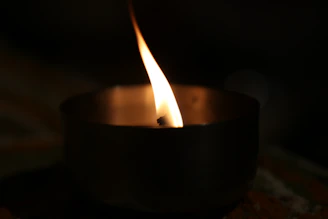 Close-up of a flickering flame in a sleek black matte candle holder.