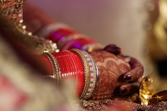 Close-up of a bride's hands adorned with detailed floral mehndi designs.