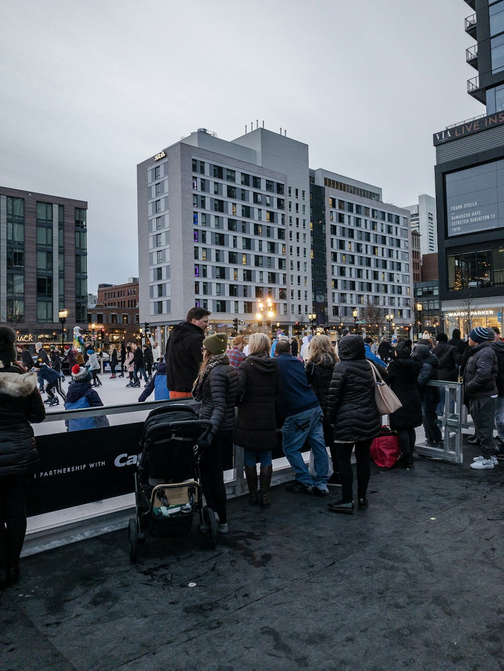 Multitud de personas paradas en la calle cerca de los edificios durante el día