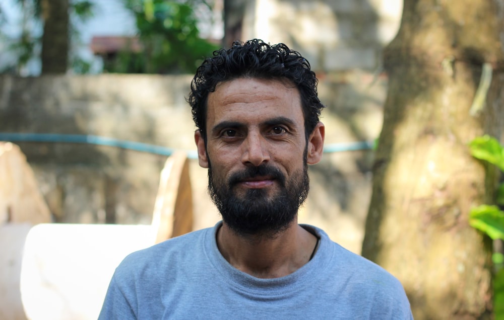 man wearing blue crew-neck shirt smiling