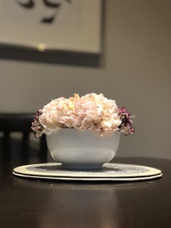 A rustic ceramic bowl filled with fresh wildflowers, sitting on a wooden table.
