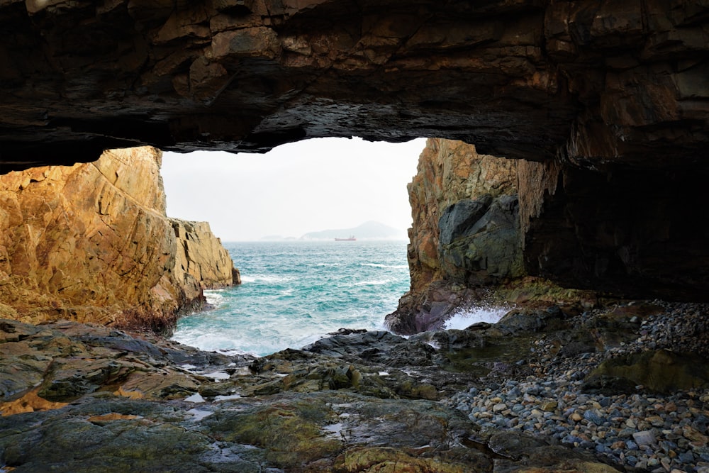 a cave leading to the beach during daytime