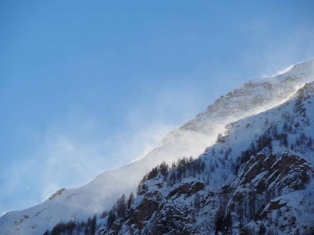 low-angle photography of snowy mountain under a calm blue sky
