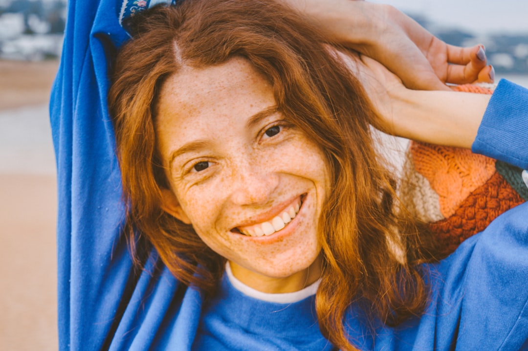 woman wearing blue crew-neck sweater smiling