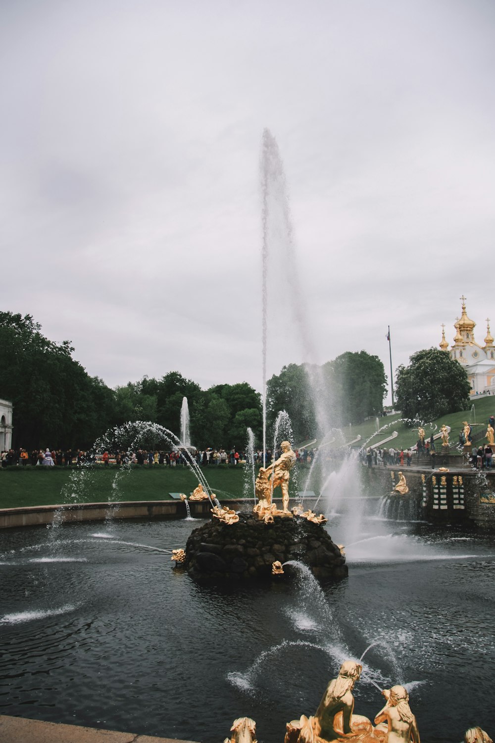 outdoor water fountain near green field under white sky