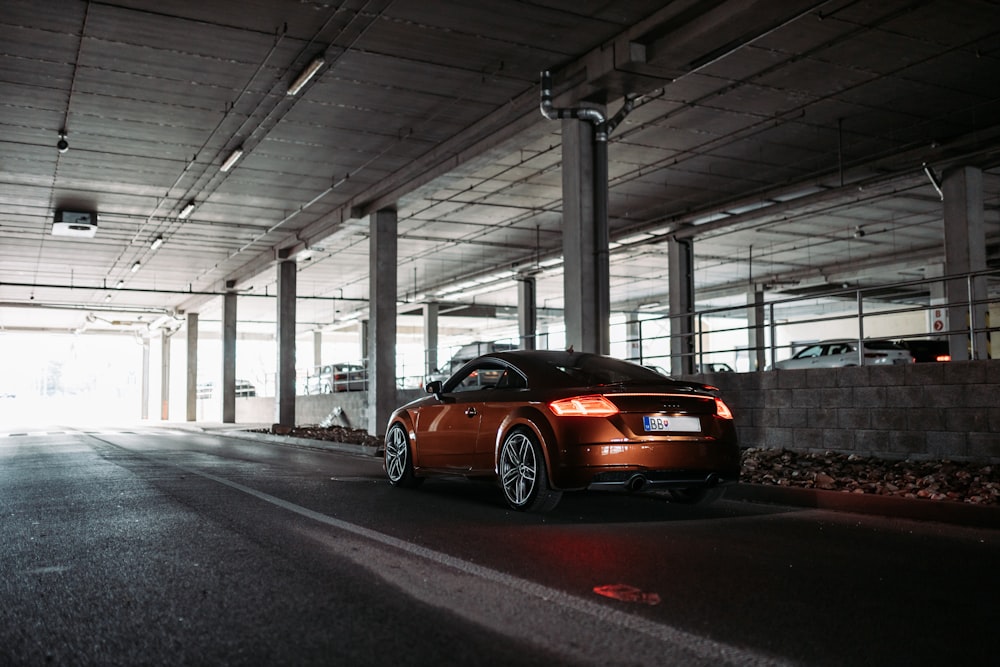 Audi TT coupé marrón dentro del estacionamiento cubierto