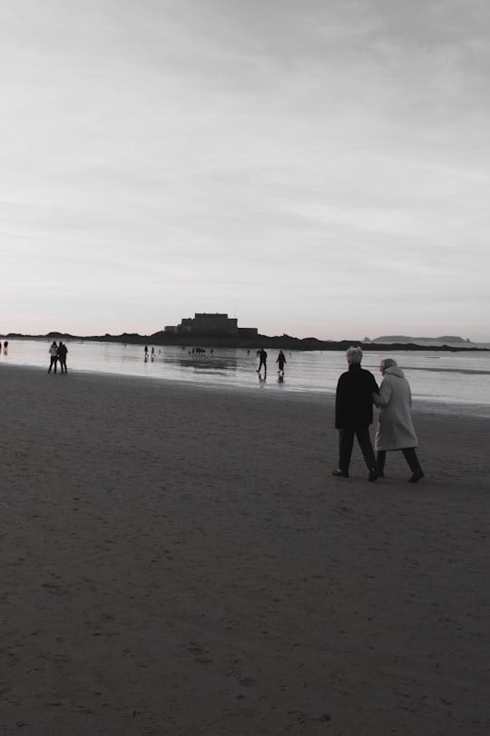grayscale photo of people on seashore during daytime in Saint-Malo France