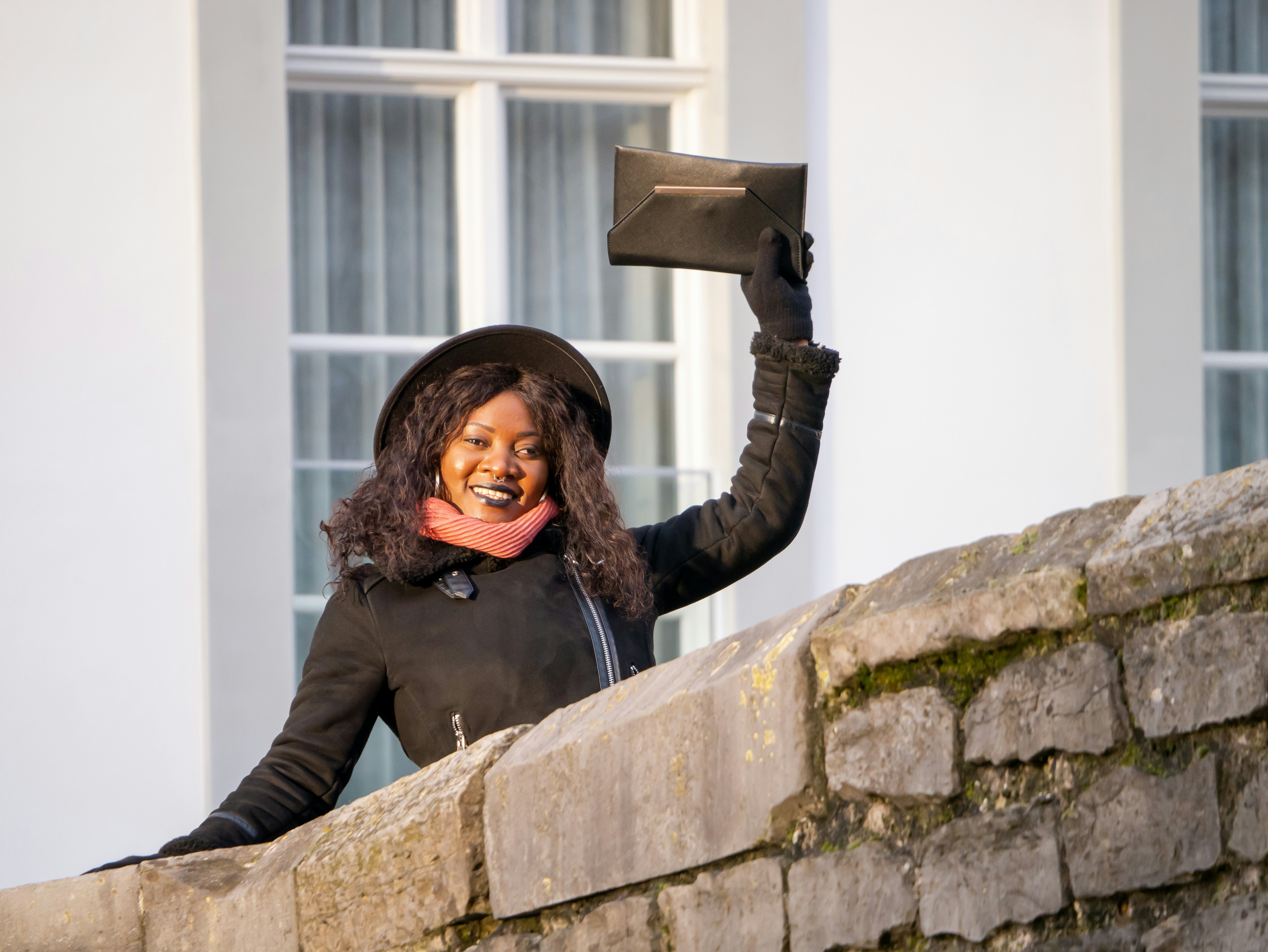 woman holding a black envelope purse
