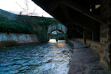 Calm river flowing beneath an ancient bridge near a revered holy shrine