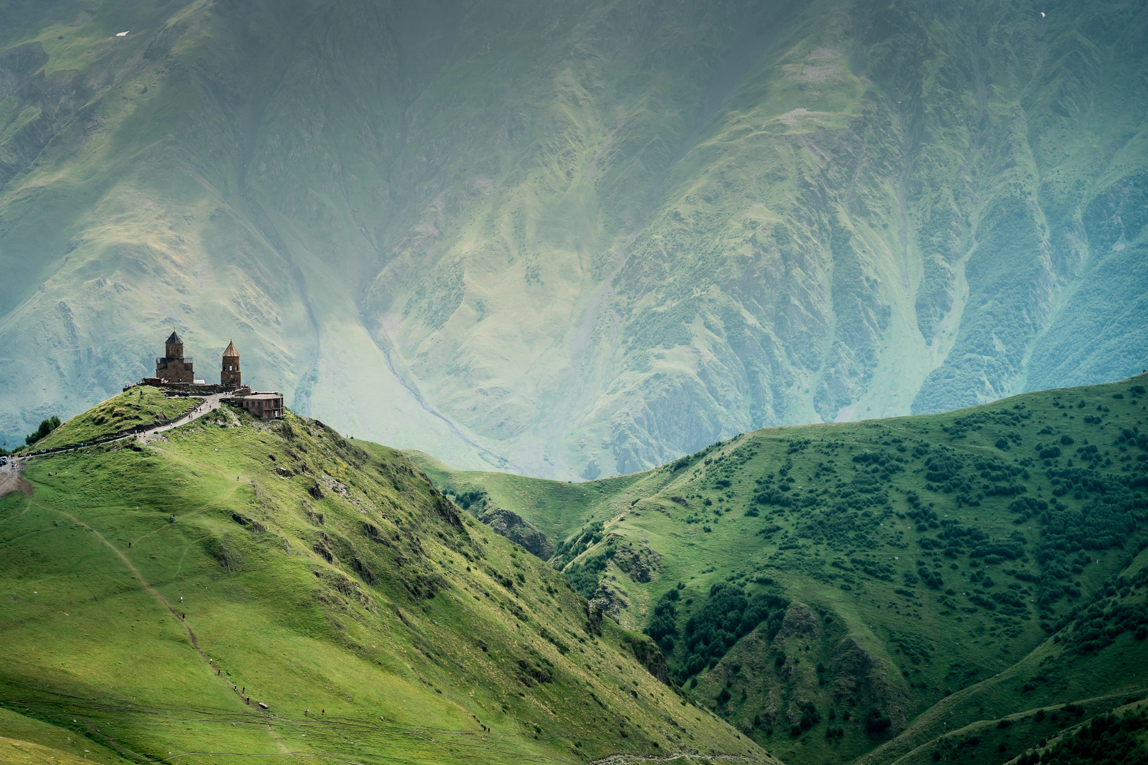 Gergeti Trinity Church on a green ridge in the Caucasus Mountains near Stepantsminda, Georgia