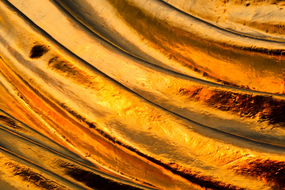 a close up of a metal object with gold paint