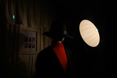 A cozy indoor scene featuring a mannequin dressed in layered elegant clothing with soft golden lighting.