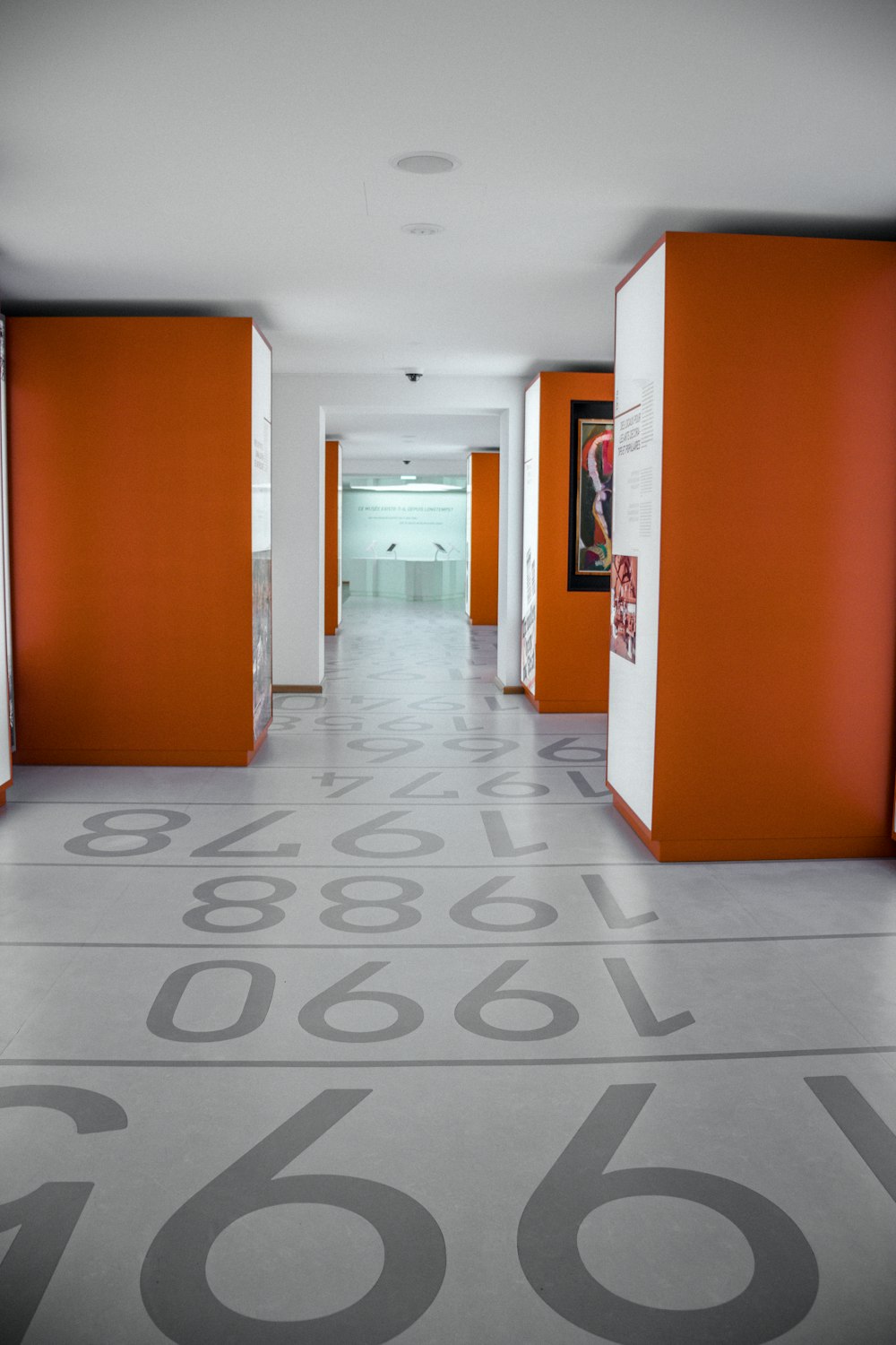 an orange and white hallway with numbers painted on the floor