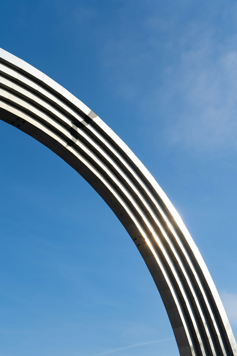 a large metal arch with a sky background