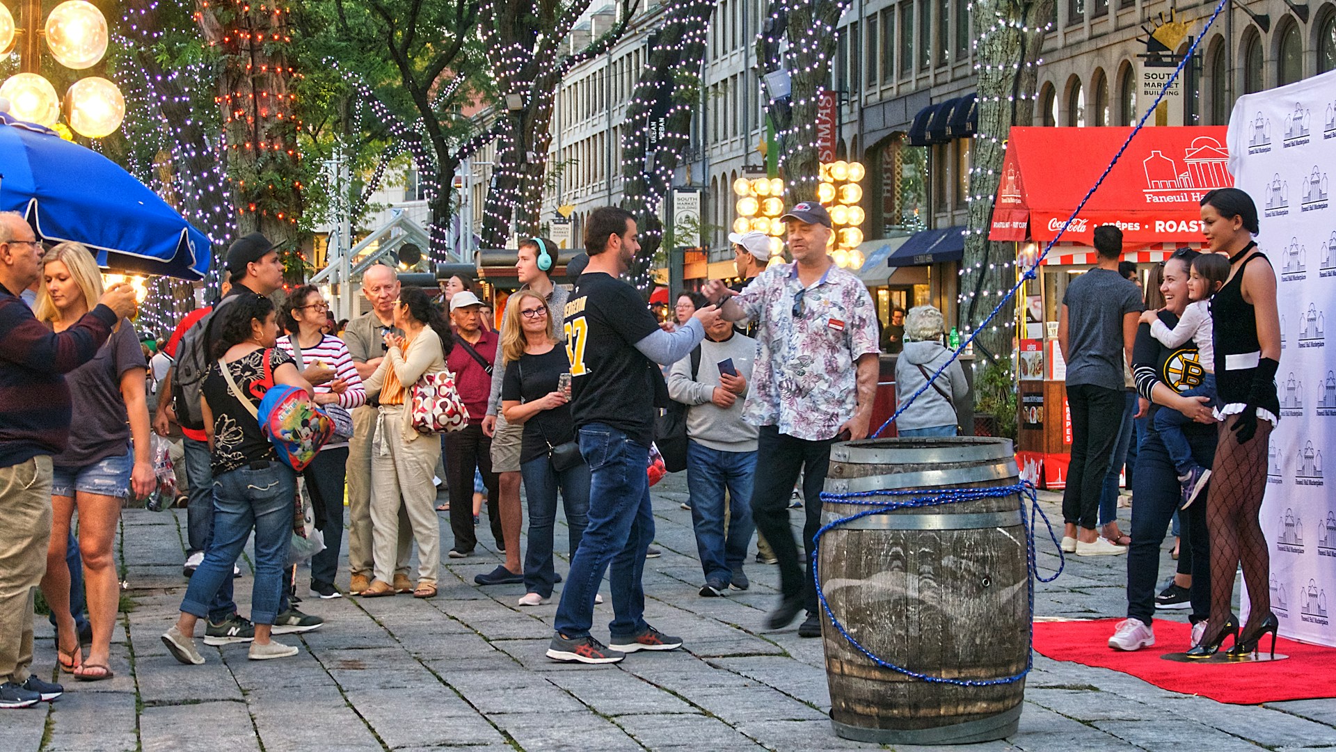 A bustling city street transformed for a large-scale community event, featuring branded tents and engaged attendees.