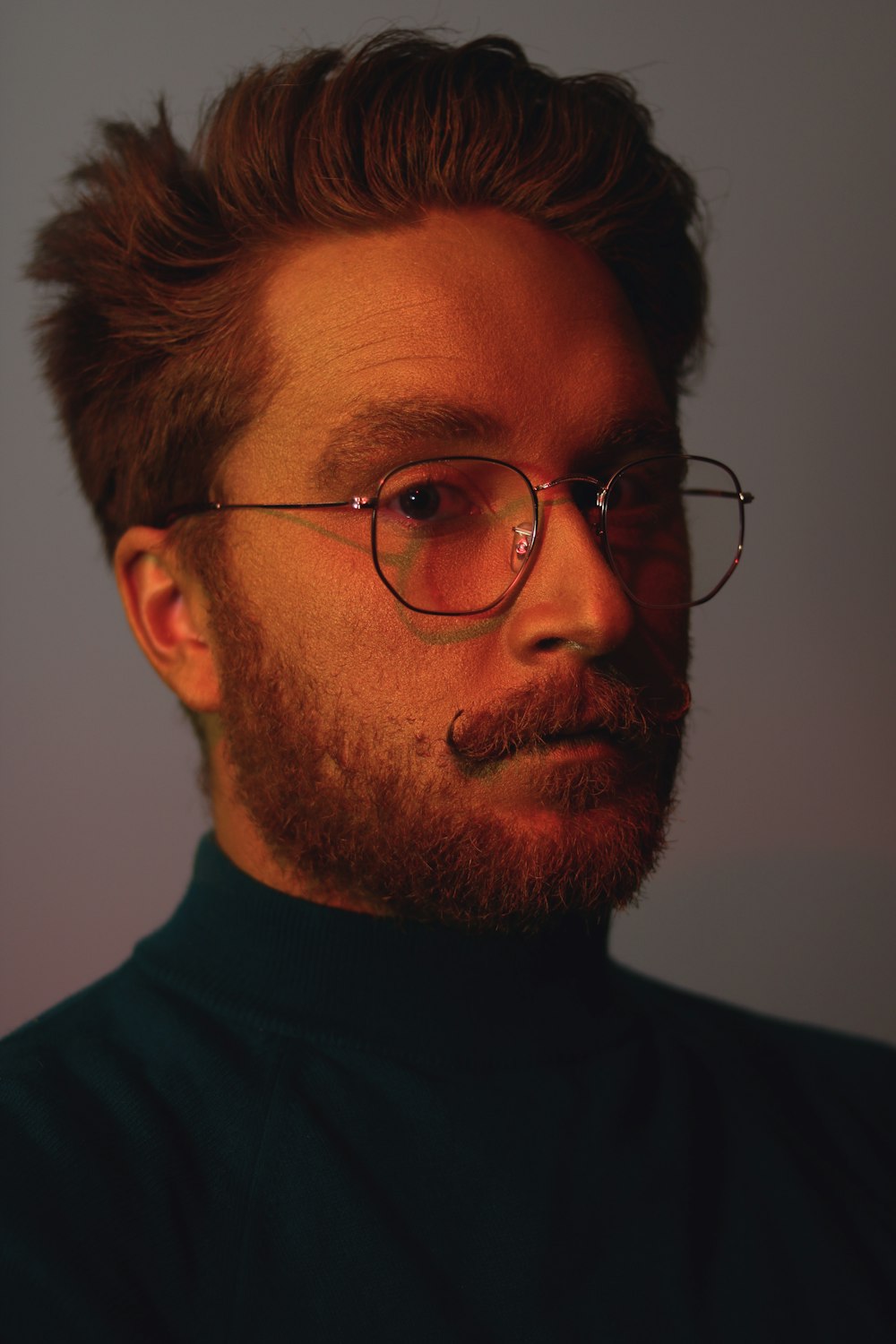 Photo de mise au point superficielle d’un homme en chemise à col roulé noire portant des lunettes