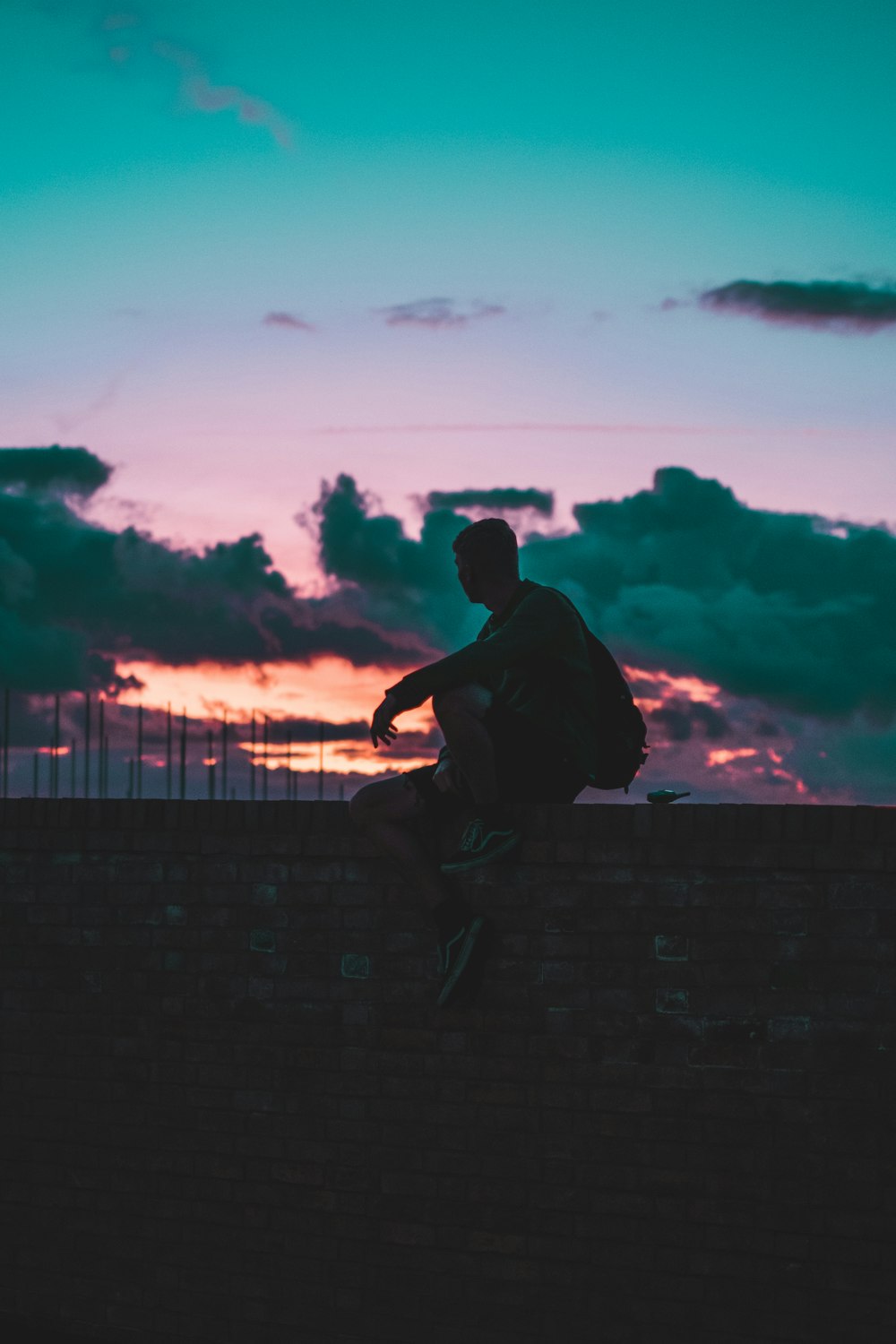 person sitting on wall during day