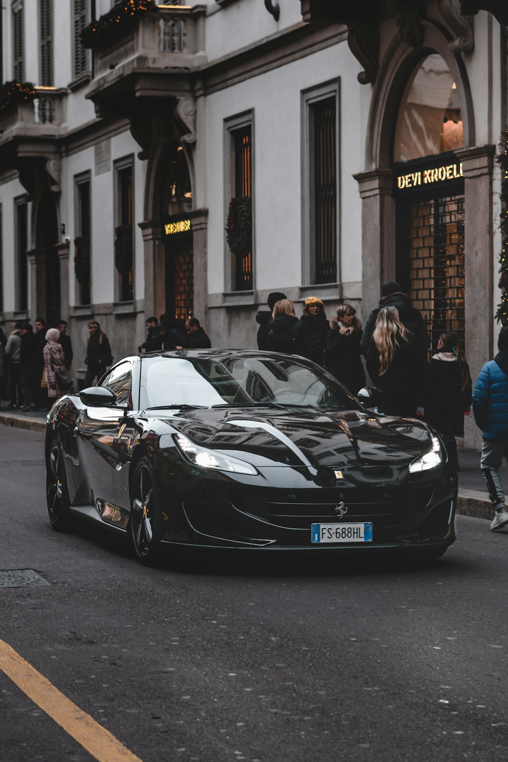 black car near people during day