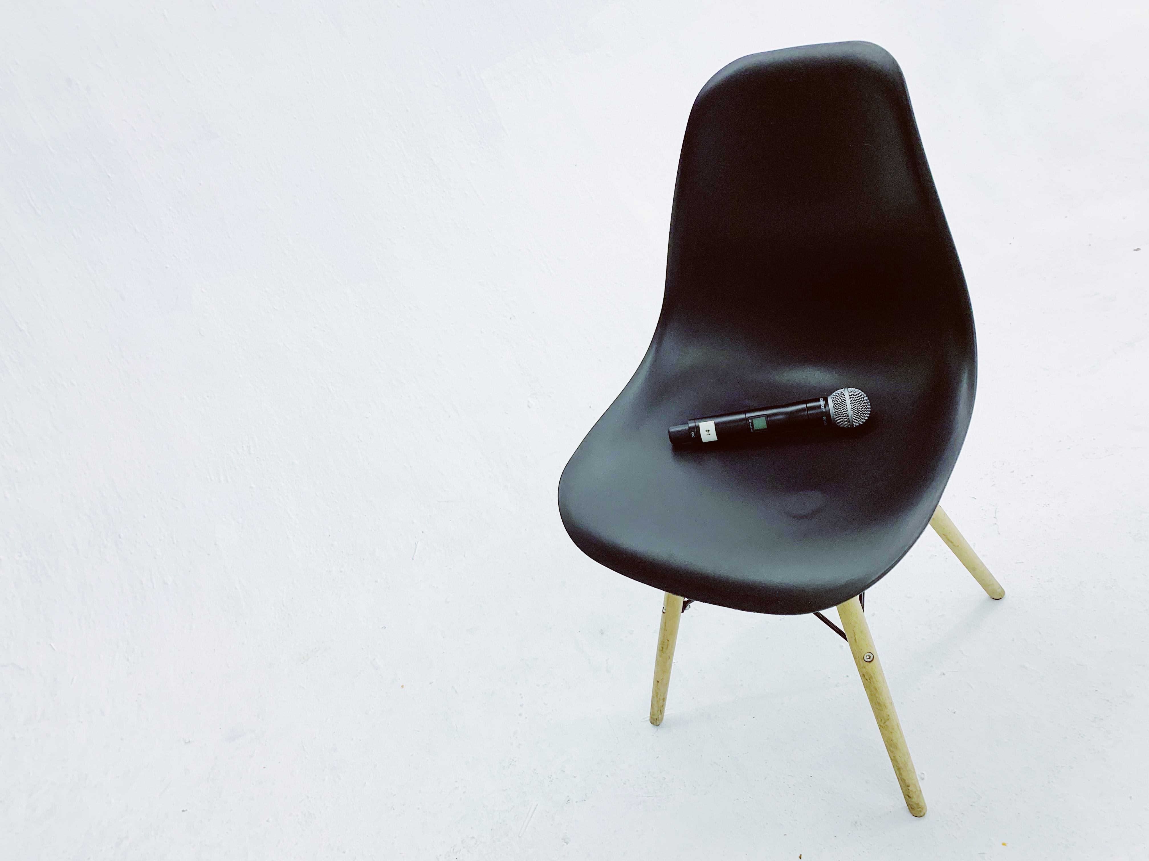 black wireless microphone on black armless chair