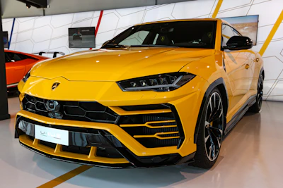 A hand selecting a car model on a sleek digital booking interface with yellow and black accents.