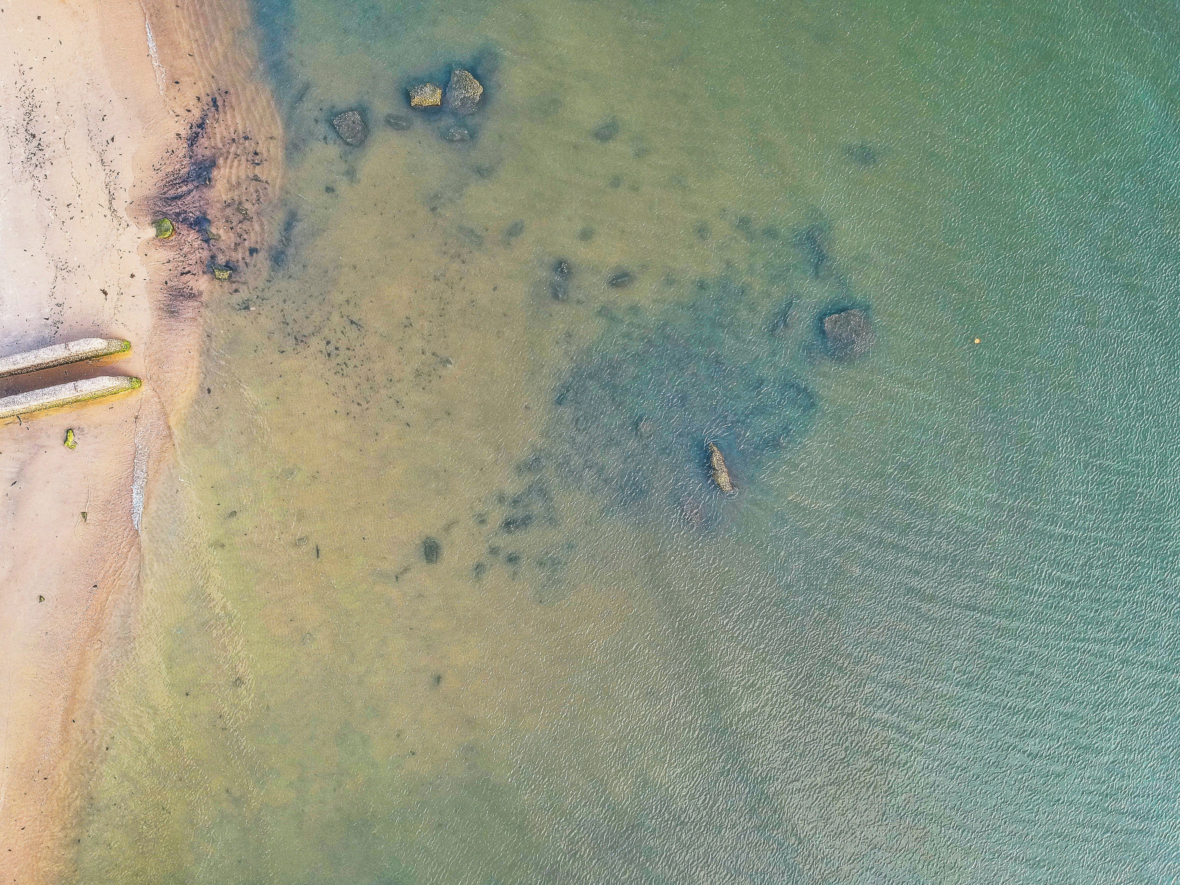 aerial photography of rock formations on body of water during daytime